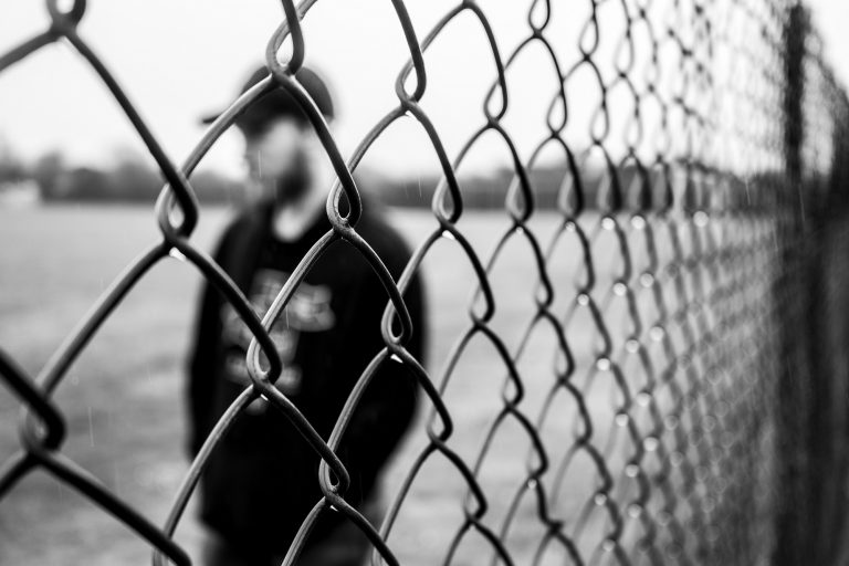 Uomo dietro una grata | © Jake Oates